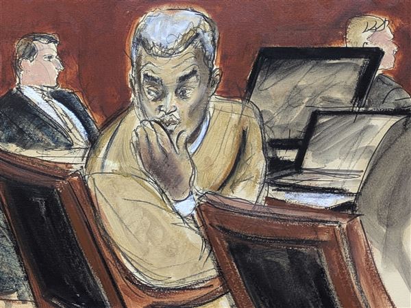 Sean "Diddy" Combs, right, blows kisses to people in the audience during his sex trafficking and racketeering trial in Manhattan federal court Monday in New York.