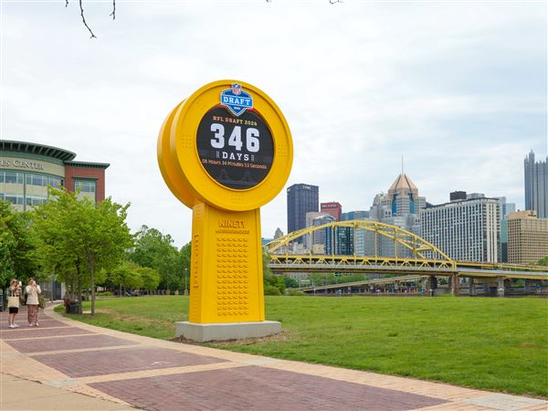 Walkers on the North Shore stop to take pictures of the 2026 NFL Draft countdown clock at the North Shore Great Lawn, Monday. State tourism officials said that Pa. will be the sports epicenter of the country next year, with the NFL draft, a PGA major event, MLB all-star game and World Cup soccer games all being staged here.
