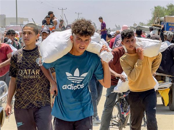 Displaced Palestinians receive humanitarian aid packages from a U.S.-backed foundation Tuesday, June 10, 2025, in Rafah, southern Gaza Strip.