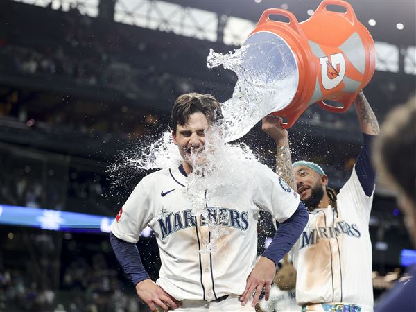 The Mariners' Cole Young is dunked with water by J.P. Crawford after reaching first on a fielder's choice that allowed Miles Mastrobuoni to score the walk-off run during the 11th inning of a game against the Minnesota Twins on Saturday, May 31, 2025, in Seattle.