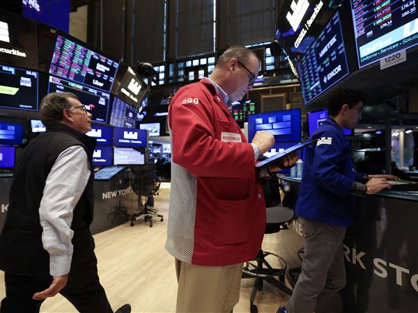 Traders looks at a tablet on the floor of the New York Stock Exchange (NYSE).       