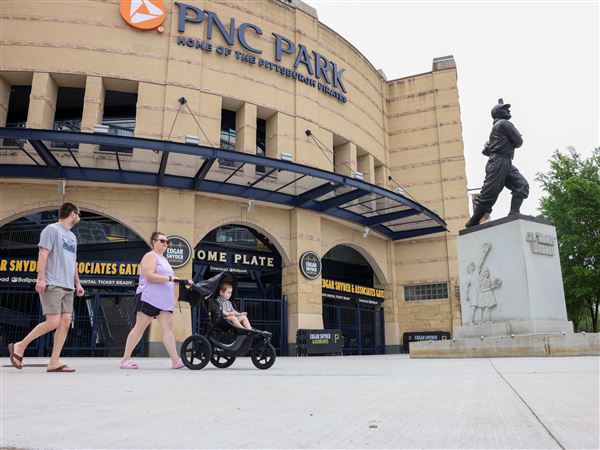 Kelsey Karinsky and Owen Cramp push Noah Cramp in a stroller across newly poured concrete where the Bucco Bricks once lay, near the Home Plate gate at PNC Park,  Wednesday, May 14, 2025. 