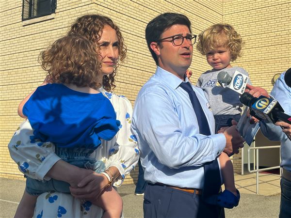 Corey O’Connor talks to the media after he and wife Katie voted at Linden Pre-K in Point Breeze. Katie is holding daughter Molly and Corey holds their son Emmett.