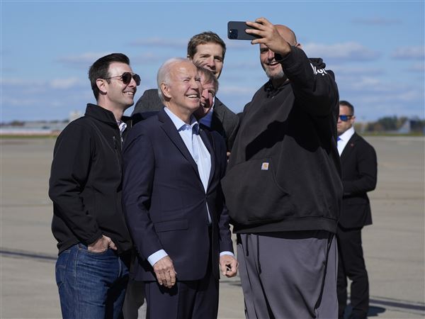 President Joe Biden, center, takes a selfie with Sen. John Fetterman, D-Pa., right, upon arriving at Pittsburgh International Airport in Pittsburgh, Saturday, Oct. 26, 2024, to attend a campaign event. (AP Photo/Manuel Balce Ceneta)