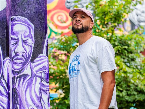 Kyle Holbrook stands next to a mural he created at the Afro-American Music Institute, Homewood, in 2023. Two of his murals, one in Miami and another in Oakland, Calif., were defaced with racial epithets and a swastika in the past two weeks.